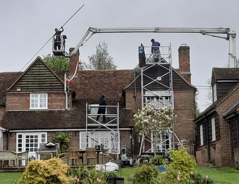 The Moss Cleaners using cherry picker and scaffolding to clean roof safely and professionally in Godalming, Surrey